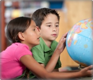 Image of young students looking at a globe