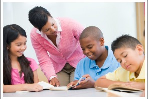 Teacher helping elementary school reading group